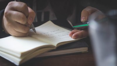 人物在夜间书桌前独自工作，周围散落着笔记和书籍，展示哥布林重度依赖复发后重新整理状态的场景